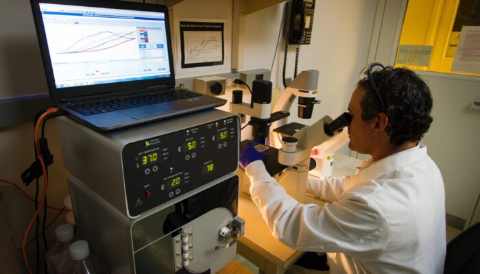 Researcher looking through microscope in a lab